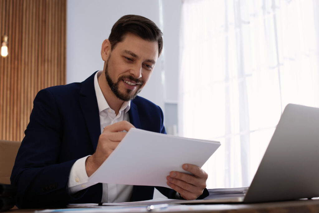 Business person looking through documents in a business office setting - Good skills to have on a resume